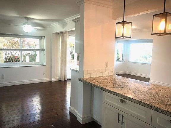 Kitchen counter looking into kitchen eating area with bay window