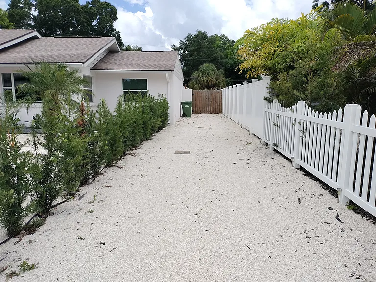 View from Bougainvillea St of gravel driveway as well as gated entrance to the unit