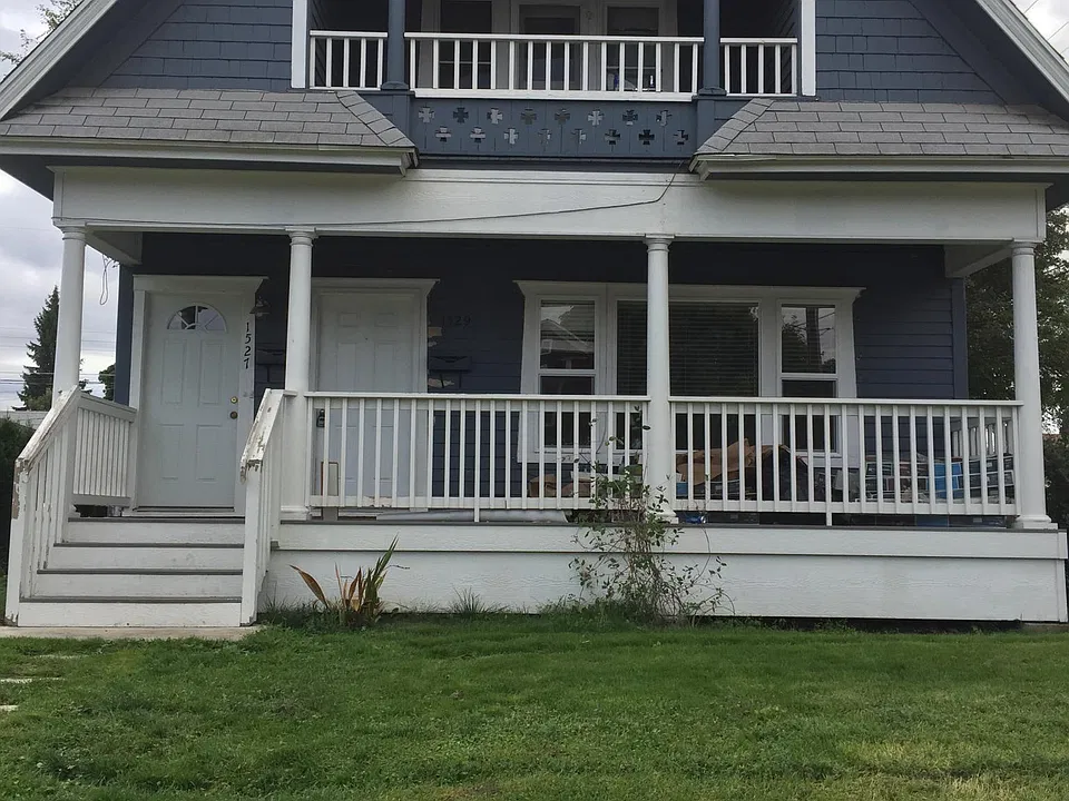 Upstairs apartment left door entry with security camera at front door for house.