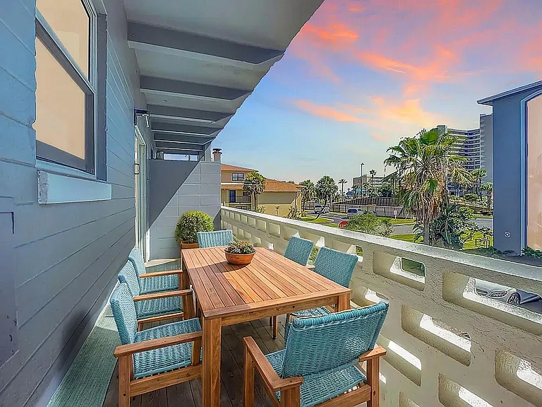 Charming balcony with comfortable seating and scenic sunset views, perfect for relaxation and outdoor dining.