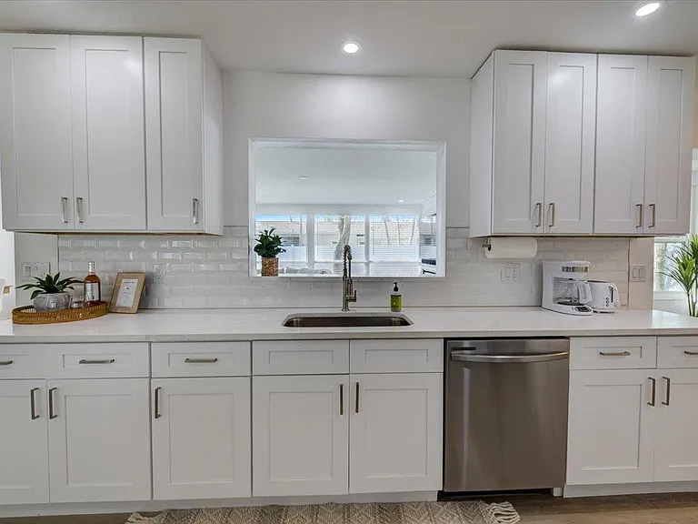 Kitchen window frame sees into back living room
