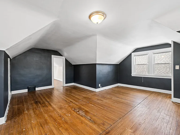 This photo shows another angle of the larger third floor/second level of the unit. It shows the entrance into the second, smaller room on the same level.