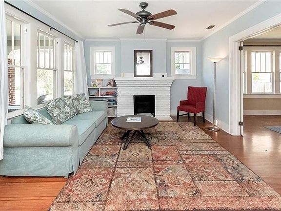 Living room with crown molding, a fireplace, and hardwood / wood-style flooring