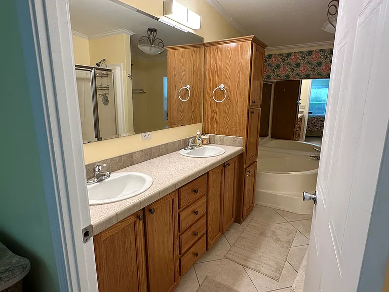 Master bath with double (his and her) sinks with large tub and oak cabinet storage! View #2