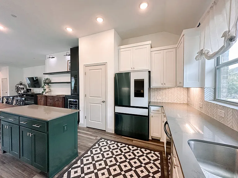 Kitchen featuring refrigerator, wine fridge, open shelving, statement island