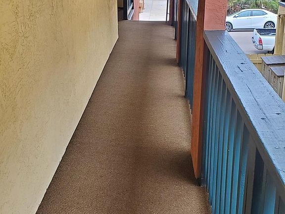 Exterior hallway leads to stairs on both sides which take you down to gate or garage.