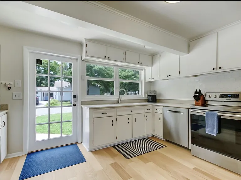Kitchen pictured with original cabinets but new appliances. Will include additional wooden island that goes across from the oven. Pictured is the side door with a key pad for entry.