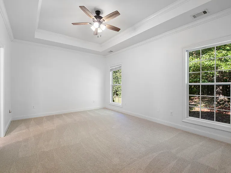 The large primary bedroom is located at the rear of the home. New carpet and lighting create a fresh retreat, and a large walk-in closet offers ample storage.