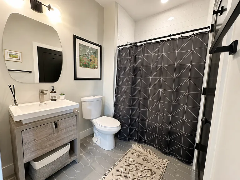 Downstairs full bathroom opens to the first floor bedroom and the main living space.
