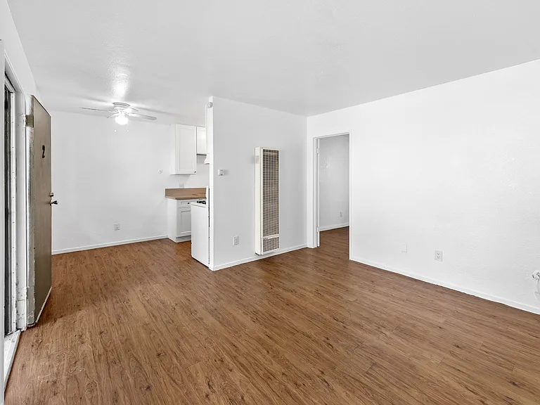 Living room to kitchen and dining area with new fan, all new paint throughout, all new appliances