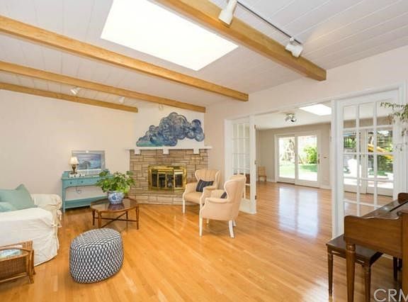 Bright Living room with stone fireplace, beamed ceilings and built-ins