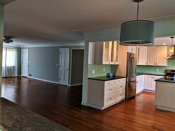 View from sun room into spacious kitchen, dining room and living room.