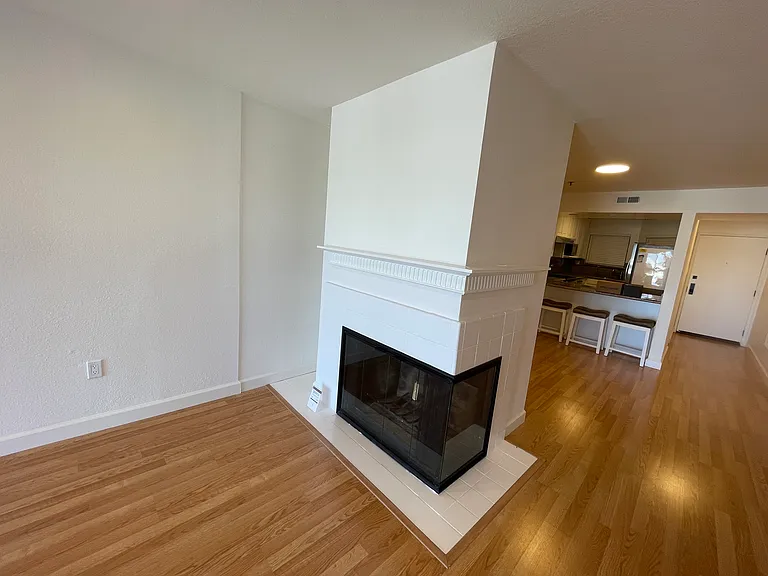 White contemporary fireplace situated between dining and living areas