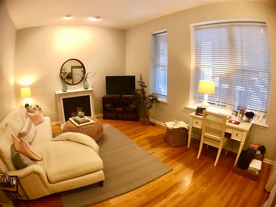 Living room, 10-foot ceilings, fireplace, hardwood floors throughout. Open to the kitchen.