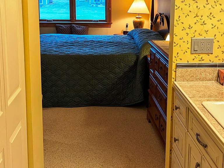 view of master bedroom past ensuite vanity area from open pocket door.