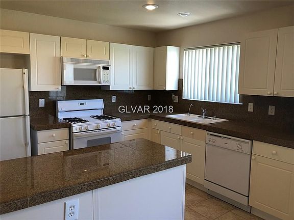 GRANITE COUNTERS AND BACKSPLASH IN FUNCTIONAL KITCHEN