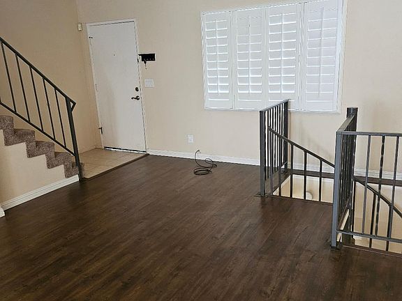Living room with shutters and spiral stairs to garage.