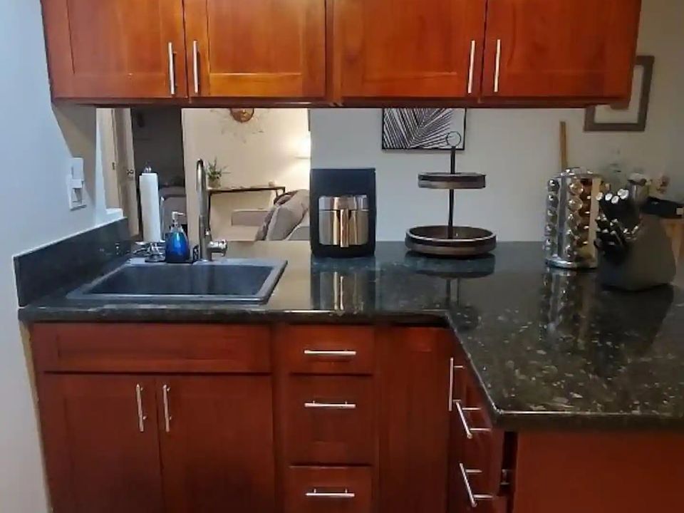 Open kitchen, with microwave, stove, and refrigerator. Full stocked with utensils.