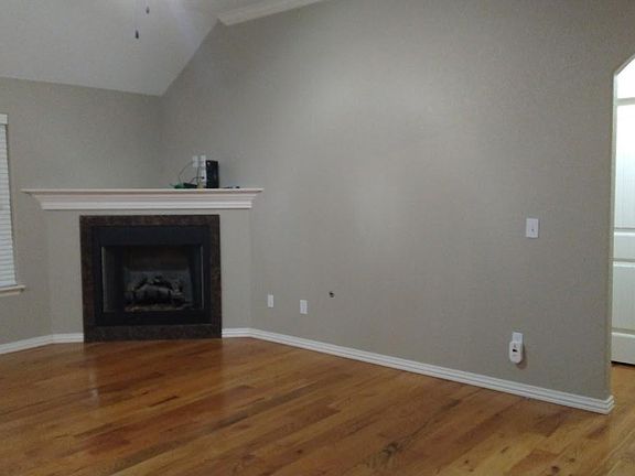 The open concept living/dining/kitchen has been painted a neutral greige. The fireplace lends warmth to the space in the winter months.