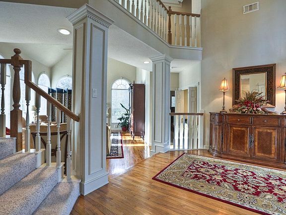 View of family room from entry features columns and front staircase.