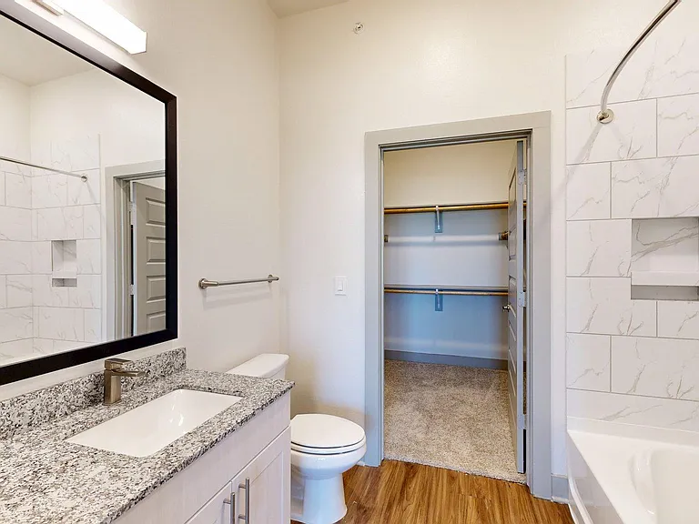 Apartment Bathroom with LED vanity mirror and Tile Floor.