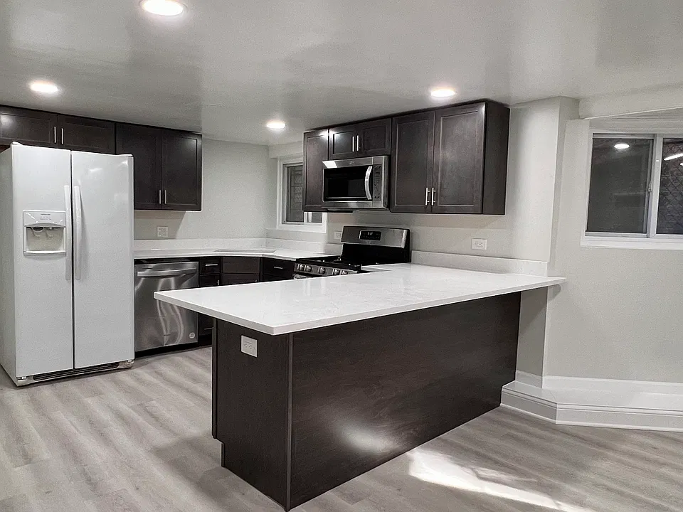 Full size fridge, dishwasher, quartz countertops w/ eat in bar, and gas stove