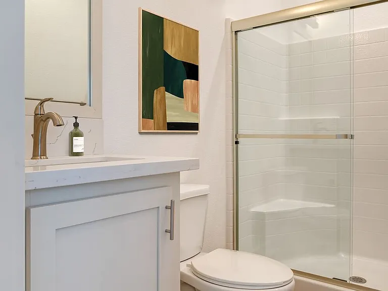 Freestanding Home bath with white quartz countertops, white cabinetry, and hard surface flooring