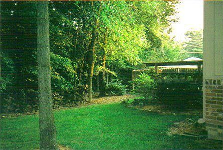 Path leads to lawn area around the corner