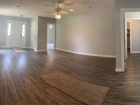 panorama of open LR, door to primary bedroom, hall to guest rooms