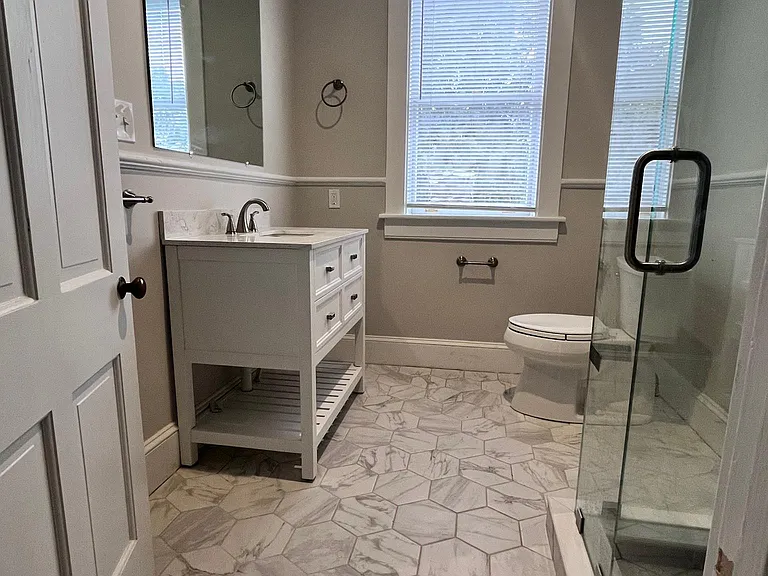 Spacious bathroom with large vanity and custom tilework and glass enclosure for shower