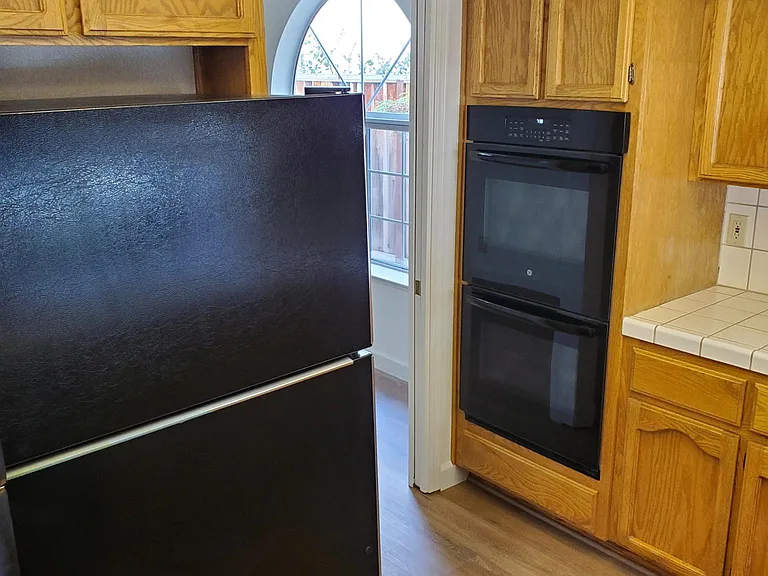 Kitchen with view of refrigerator, gas range stove, and cabinetry