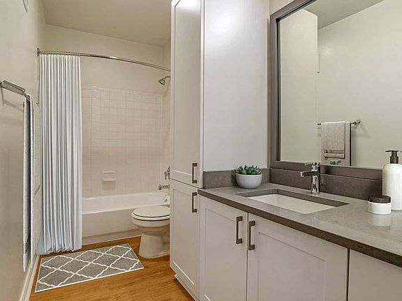 Newly renovated Finish Package V baths with white cabinetry, grey quartz countertops, and hard surface flooring