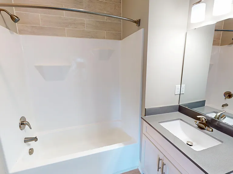 The primary en suite bathroom includes a large vanity and shower/bathtub combo. The primary en suite bathroom includes a large vanity and shower/bathtub combo.