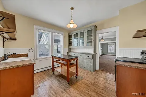 Kitchen is bathed in bright light, and features vinyl laminate floors for easy cleaning and maintenance.