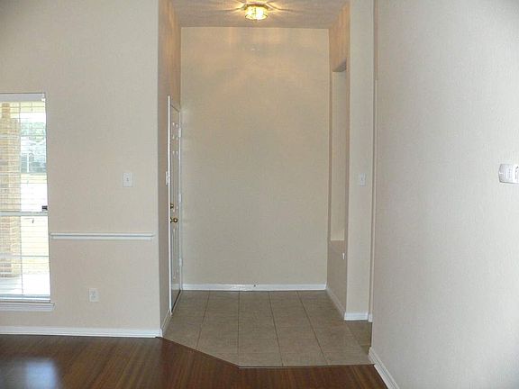 The entry to this beautiful home has a large covered patio outside and a nice art niche with accent 