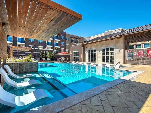 exterior pool and clubhouse with rolling overhead doors opening to the pool