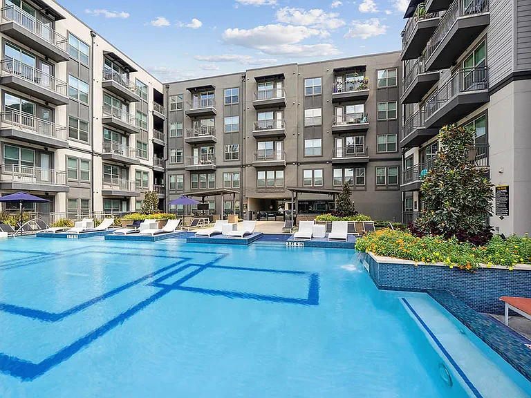 Resort-style pool with lounge chairs and gazebos.