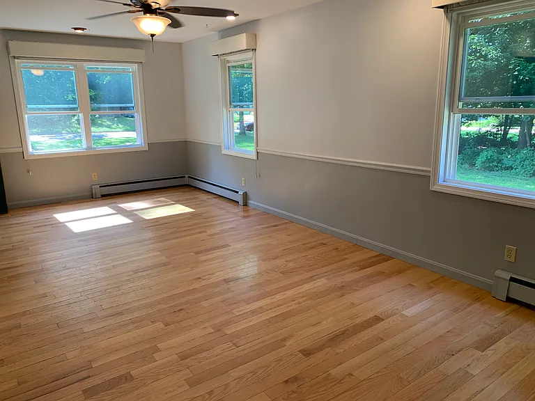 Second living room or den with thermal insulated blinds and fan.