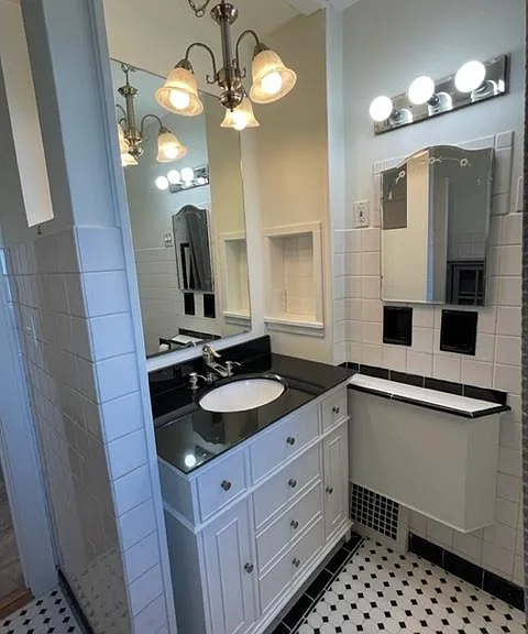 Well-lit full bath with granite vanity, make-up counter, ample storage, shower over tub, heat lamp and operable window.