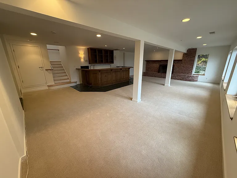 The large family room features a built-in bar featuring a mini refrigerator, sink and dishwasher.