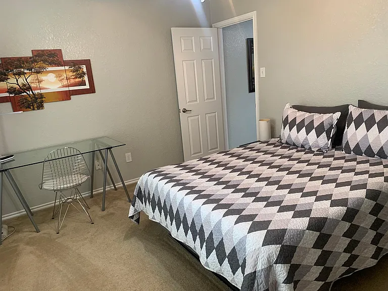 Bedroom 2 has a queen, a desk for additional work from home options, Roku TV, ceiling fan and walk in closet with a dresser.