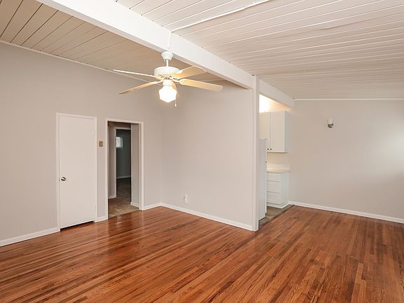 Living room and dining area with hardwood floors and vaulted ceilings