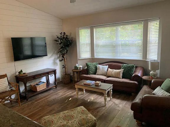 Living room with TV open to dining area and access to backyard patio