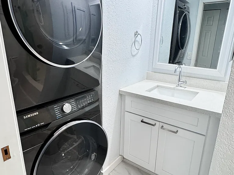 Recently renovated guest bathroom with bathtub, in unit washer and dryer and tile flooring.