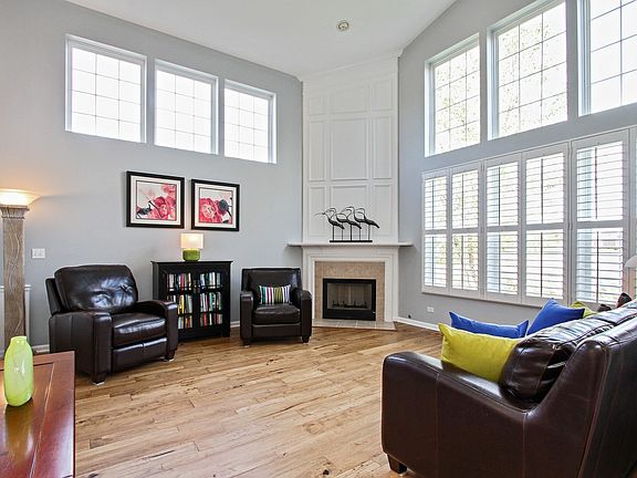 BEAUTIFUL FAMILY LIVING AREA WITH HIGH CEILINGS, GREAT NATURAL LIGHT FEATURING PLANTATION SHUTTERS AND GAS FIREPLACE