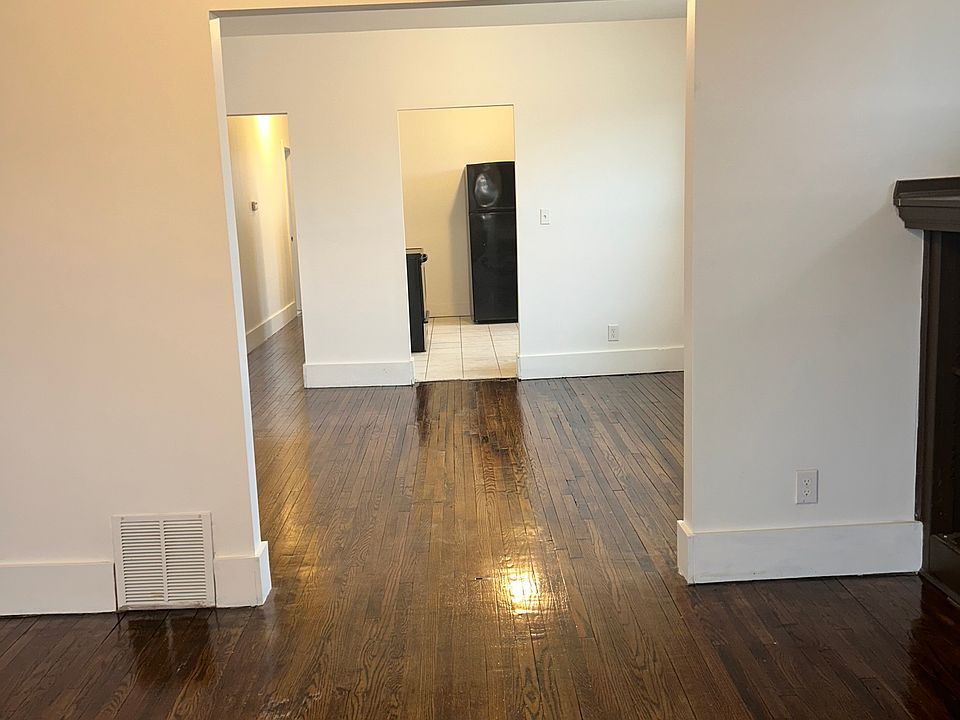View from living room back to kitchen with stainless steel stove and microwave.