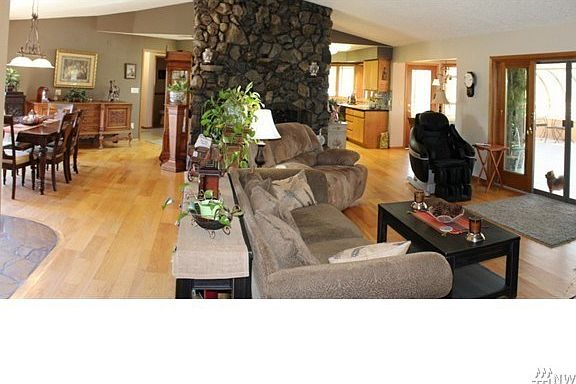 Vaulted Great Room...Features beautiful hardwood floors, wood burning fireplace with slate hearth, formal dining area plus adjoining solarium.  The back of the home offers views of the rear pastures.