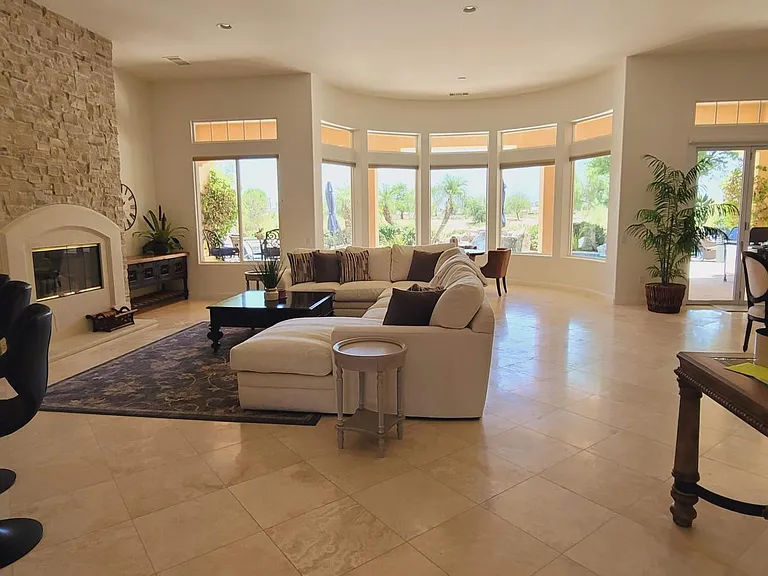 Large living area, huge couch, fireplace, and bar with stools.