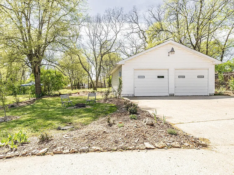 2 car detached garage! The peach tree is to the left. Not pictured are garden beds, ready for your tomatoes!
