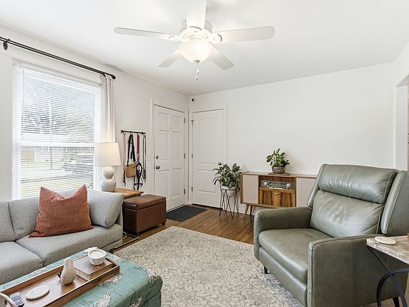 Living room with view of front door, coat closet, and entrance to kitchen area.
